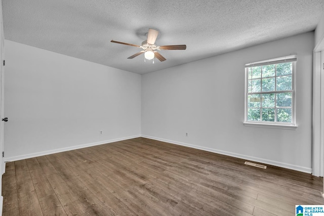 empty room featuring ceiling fan, dark hardwood / wood-style flooring, and a textured ceiling