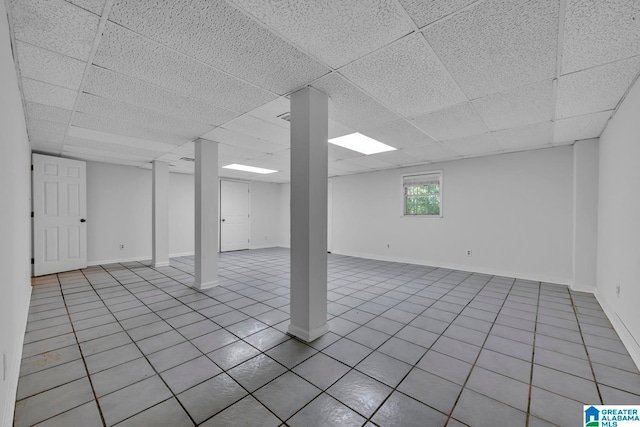 basement featuring a paneled ceiling and light tile patterned floors