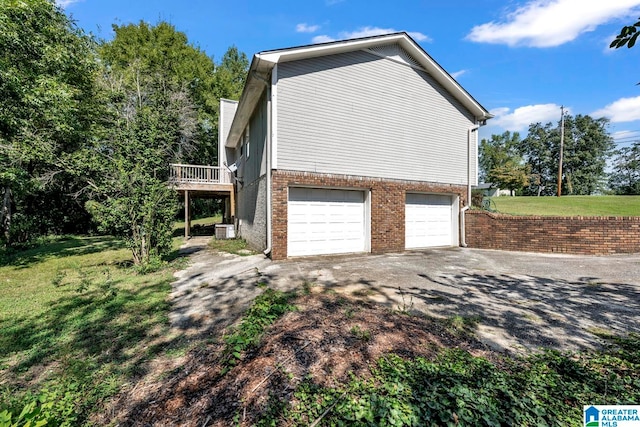 view of property exterior featuring central AC unit, a garage, a deck, and a yard