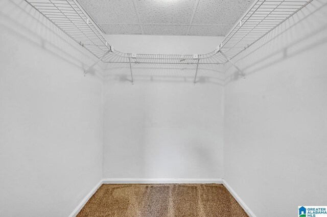 basement with a paneled ceiling and light tile patterned floors