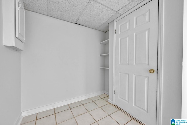 walk in closet with a paneled ceiling and light tile patterned flooring