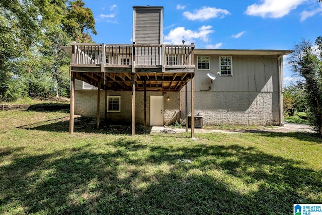 back of property with a yard and a wooden deck