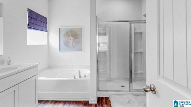 bathroom featuring wood-type flooring, vanity, and separate shower and tub