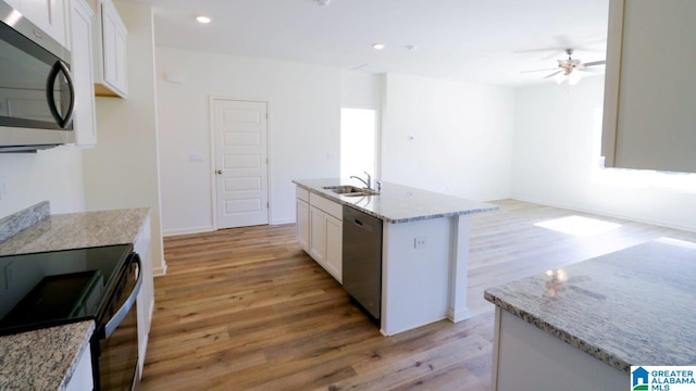 kitchen featuring an island with sink, light hardwood / wood-style flooring, white cabinets, and stainless steel appliances