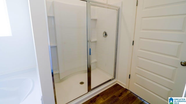 bathroom with wood-type flooring and a shower with door