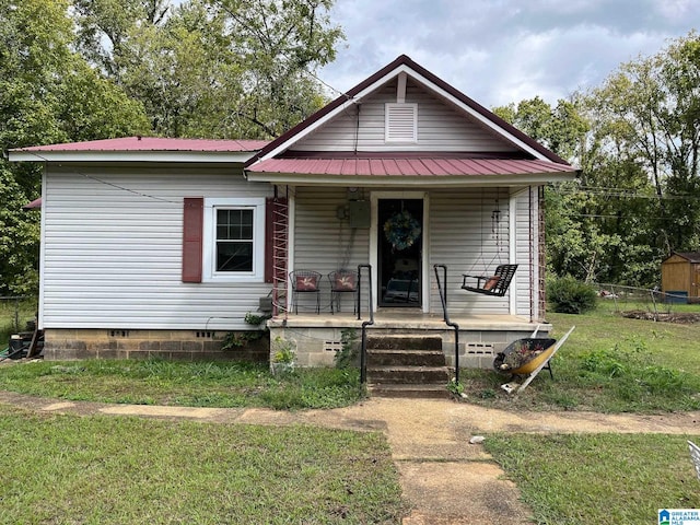 bungalow-style home with a front yard and covered porch