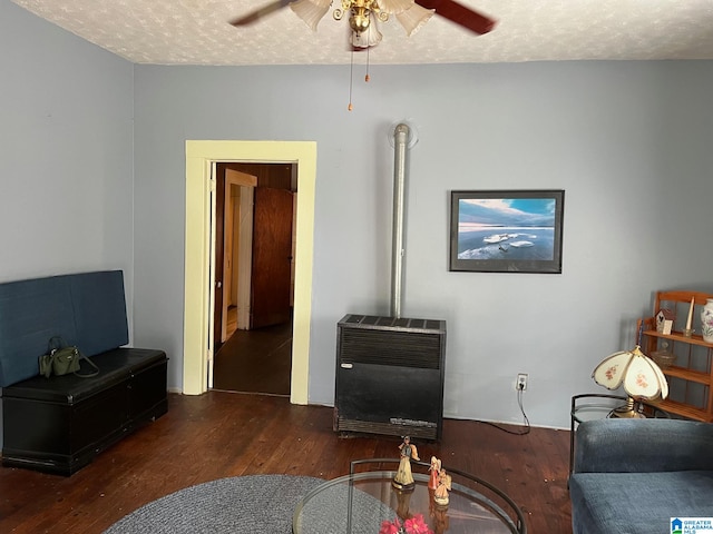 living room featuring ceiling fan, a textured ceiling, and dark hardwood / wood-style floors