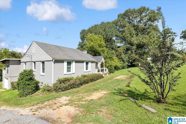 view of side of home with a lawn