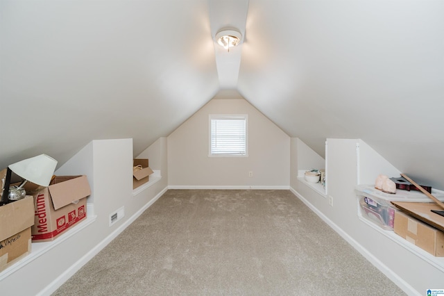 additional living space with light carpet and vaulted ceiling