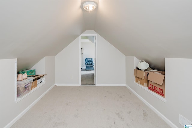 bonus room with light carpet and vaulted ceiling