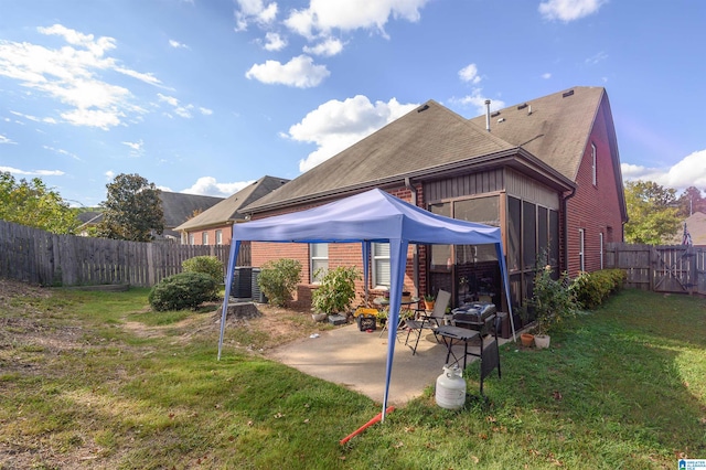 rear view of property with a yard, central AC, and a patio area