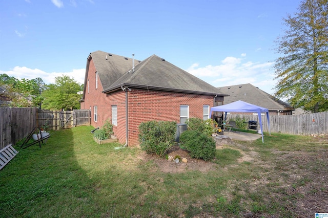 back of property with a gazebo, a yard, and a patio