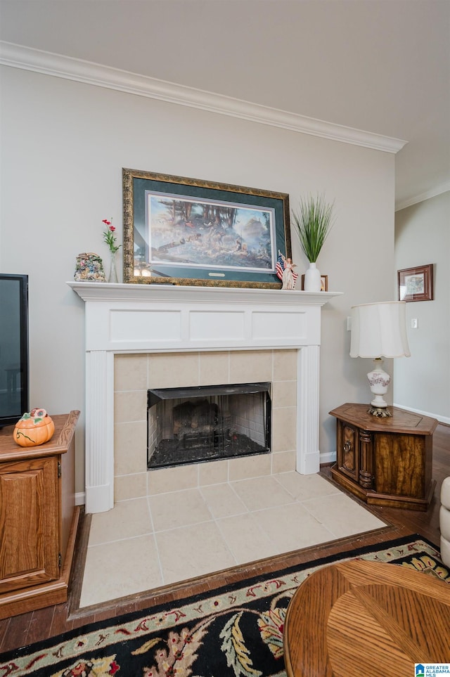 details with a tiled fireplace, hardwood / wood-style flooring, and ornamental molding