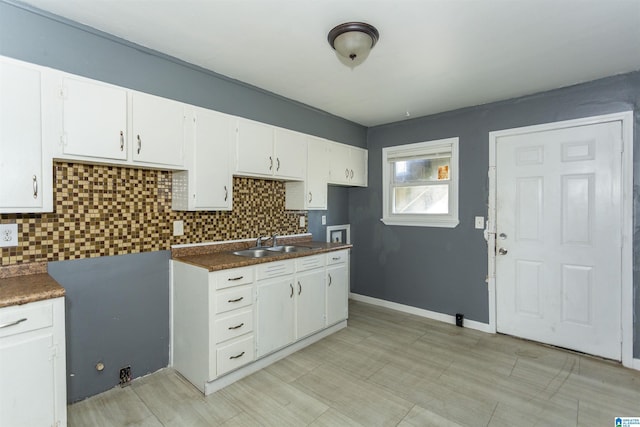7749 5th Ave, Birmingham, AL 35206 - kitchen with a sink, tasteful backsplash, white cabinetry, and dark countertops