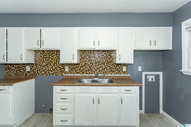 7749 5th Ave, Birmingham, AL 35206 - kitchen featuring a sink, decorative backsplash, and light wood finished floors