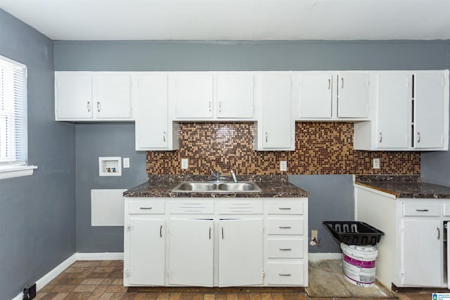 7749 5th Ave, Birmingham, AL 35206 - kitchen with a sink, baseboards, backsplash, and white cabinetry