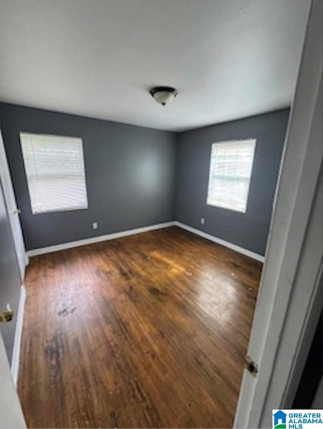 unfurnished room with dark hardwood / wood-style floors