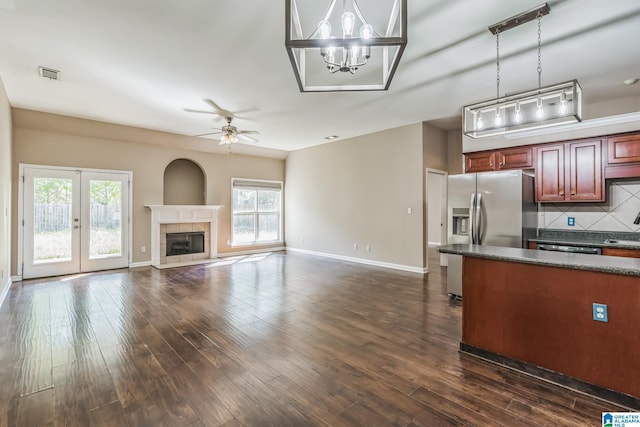 kitchen with hanging light fixtures, a healthy amount of sunlight, a fireplace, and ceiling fan with notable chandelier