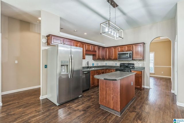 kitchen featuring a center island, dark wood-type flooring, decorative backsplash, black appliances, and decorative light fixtures