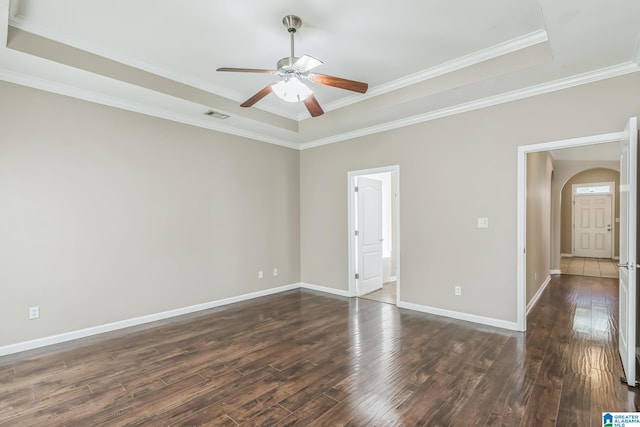 spare room with ceiling fan, a raised ceiling, dark hardwood / wood-style floors, and crown molding