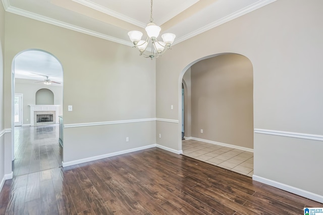 unfurnished room featuring ceiling fan with notable chandelier, dark wood-type flooring, and crown molding