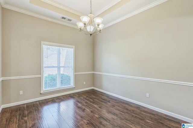 unfurnished room with a raised ceiling, ornamental molding, dark wood-type flooring, and a chandelier