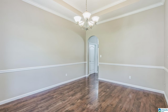 spare room featuring an inviting chandelier, ornamental molding, dark hardwood / wood-style flooring, and a tray ceiling