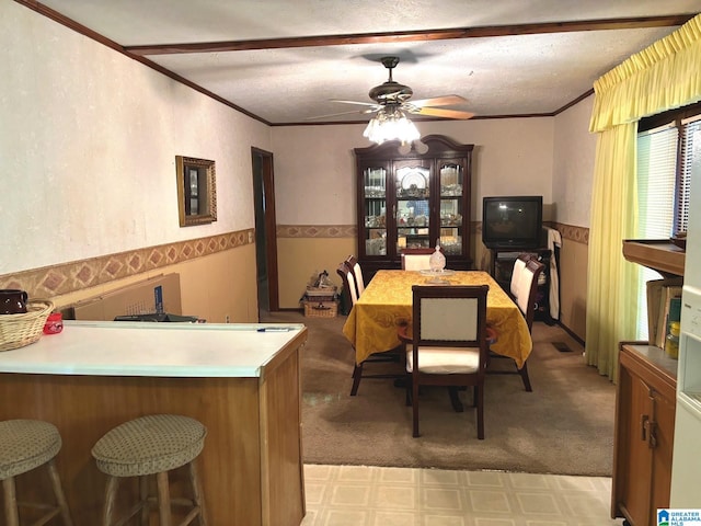 dining room featuring ornamental molding, a textured ceiling, and ceiling fan