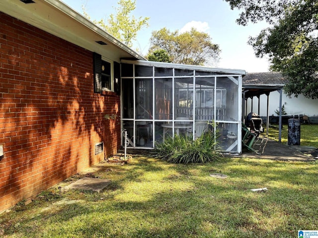 back of house with a lawn and a sunroom