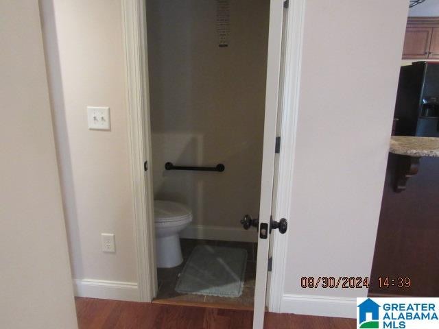 bathroom featuring hardwood / wood-style floors and toilet