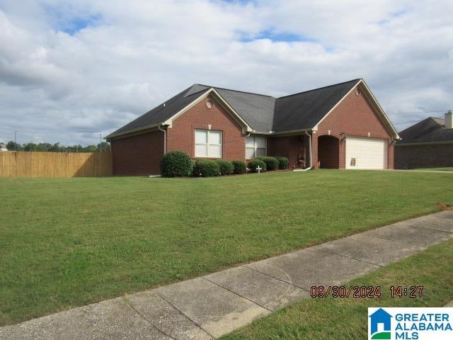 ranch-style home featuring a garage and a front lawn