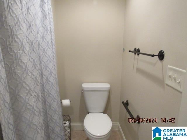 bathroom with toilet and curtained shower