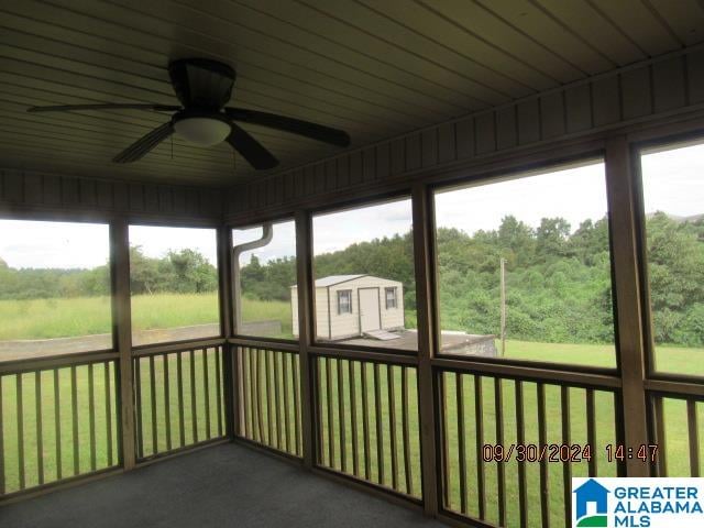 unfurnished sunroom featuring ceiling fan and plenty of natural light