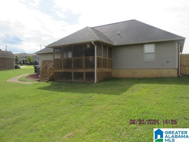 back of house with a lawn and a sunroom