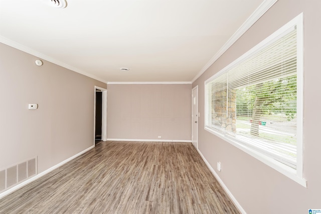 empty room featuring ornamental molding and hardwood / wood-style flooring