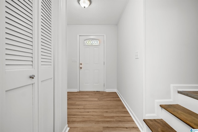 entryway with light hardwood / wood-style floors and a textured ceiling