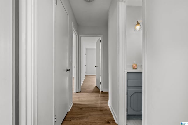 corridor with hardwood / wood-style flooring