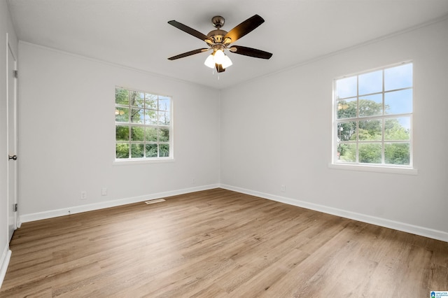 spare room with light hardwood / wood-style flooring, ceiling fan, and plenty of natural light