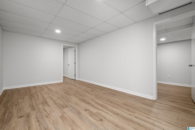 empty room featuring light wood-type flooring and a paneled ceiling