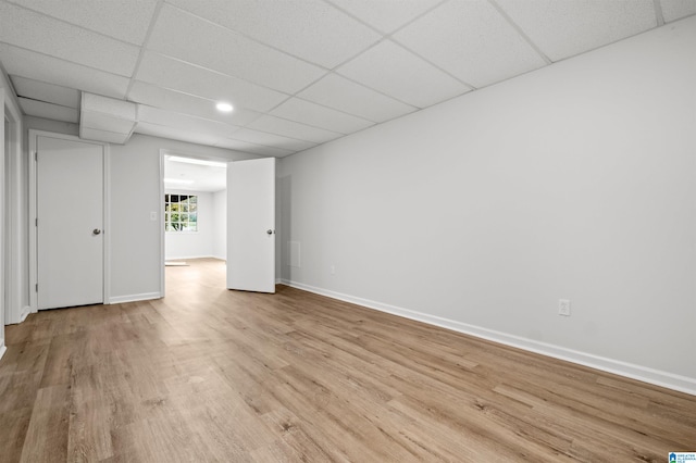 spare room featuring a drop ceiling and light wood-type flooring