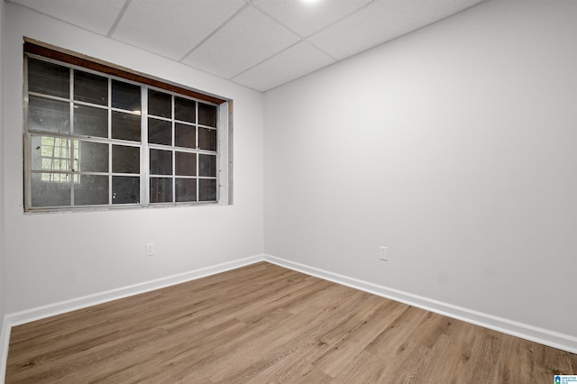 empty room with a paneled ceiling and hardwood / wood-style floors