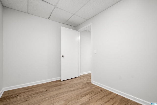 spare room with light wood-type flooring and a paneled ceiling