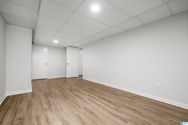 basement featuring light hardwood / wood-style flooring and a paneled ceiling