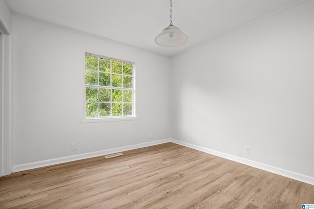 empty room featuring ornamental molding and light hardwood / wood-style floors