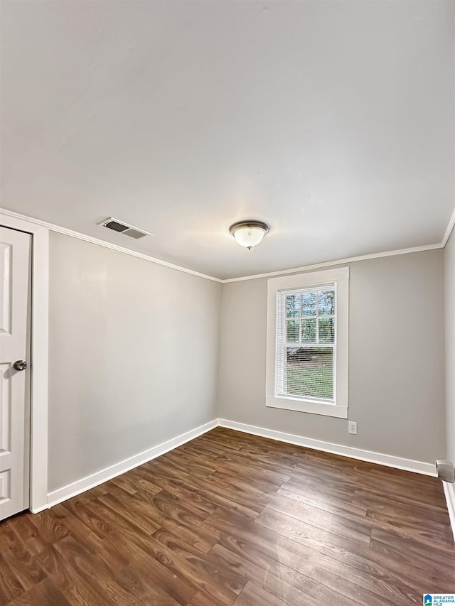 empty room with crown molding and dark hardwood / wood-style flooring