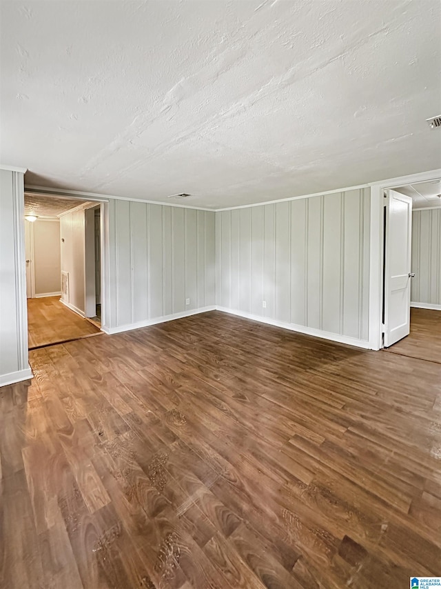 unfurnished living room featuring a textured ceiling and wood-type flooring