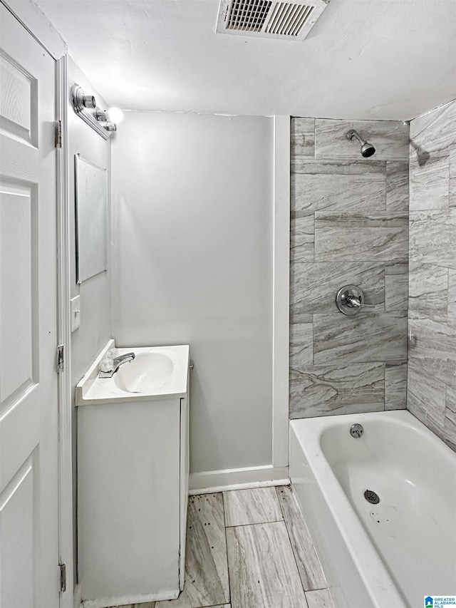 bathroom featuring vanity and tiled shower / bath combo