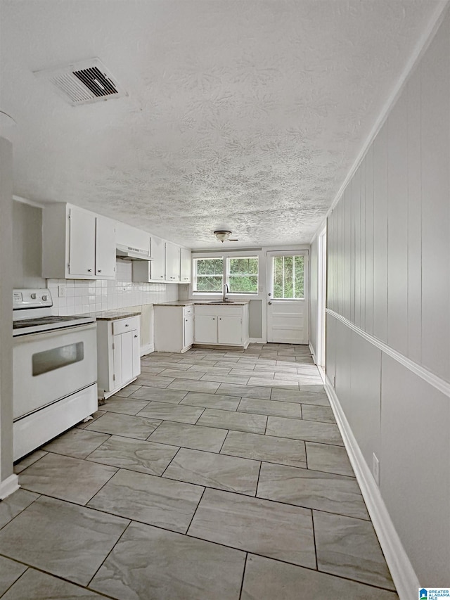 kitchen with a textured ceiling, sink, white cabinets, decorative backsplash, and white range with electric stovetop