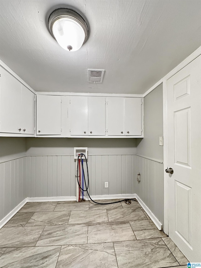 clothes washing area with washer hookup and cabinets