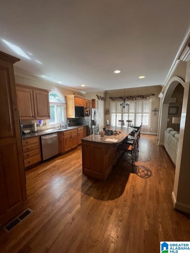 kitchen featuring wood-type flooring, appliances with stainless steel finishes, and a kitchen island